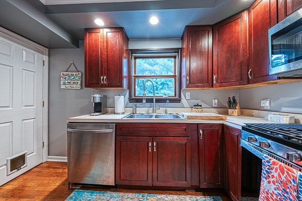 kitchen featuring light wood-type flooring, appliances with stainless steel finishes, and sink