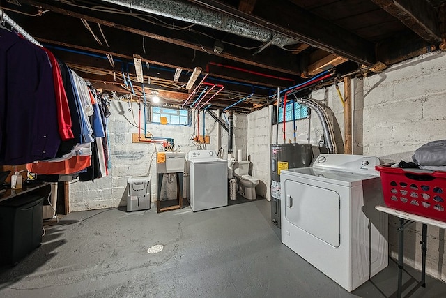 basement with sink, water heater, and separate washer and dryer