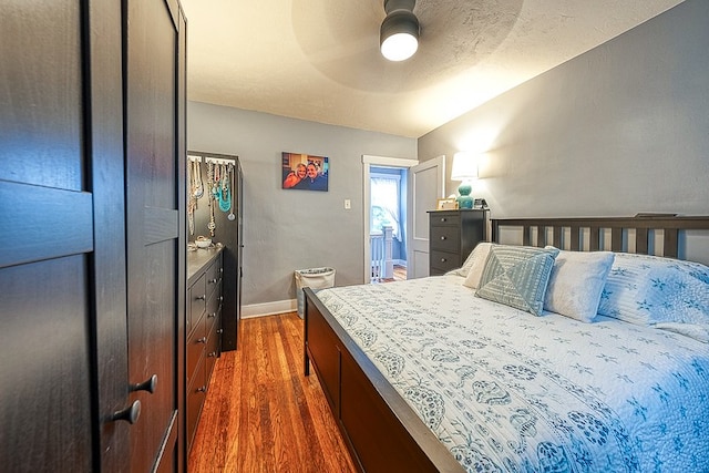 bedroom with ceiling fan, vaulted ceiling, and dark hardwood / wood-style floors