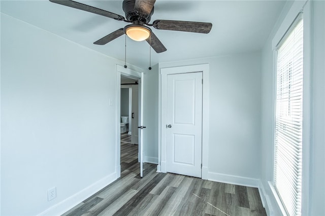 unfurnished bedroom with ceiling fan, a closet, and wood-type flooring