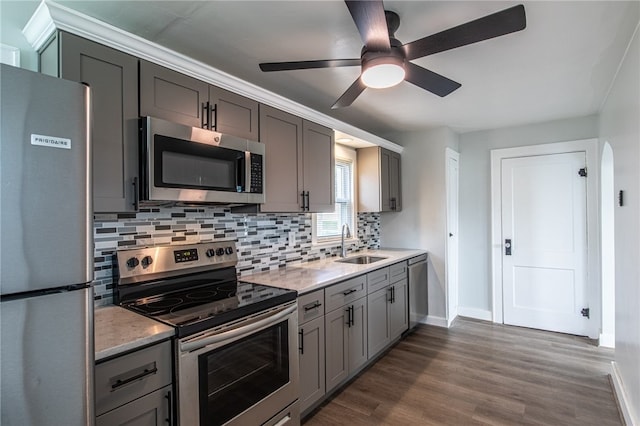 kitchen with sink, dark hardwood / wood-style flooring, appliances with stainless steel finishes, gray cabinetry, and ceiling fan