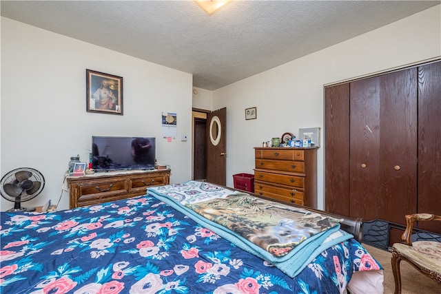 bedroom featuring a textured ceiling, a closet, and carpet