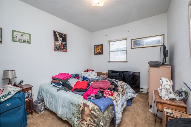 carpeted bedroom featuring a baseboard heating unit and a textured ceiling