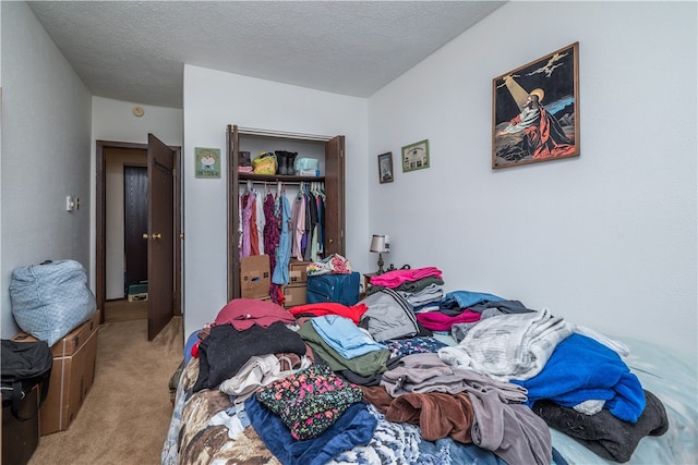 carpeted bedroom with a textured ceiling and a closet