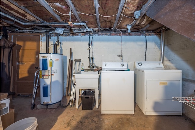 clothes washing area featuring water heater and washer and dryer