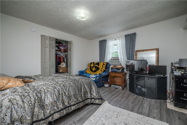 bedroom featuring hardwood / wood-style floors, a textured ceiling, and a closet