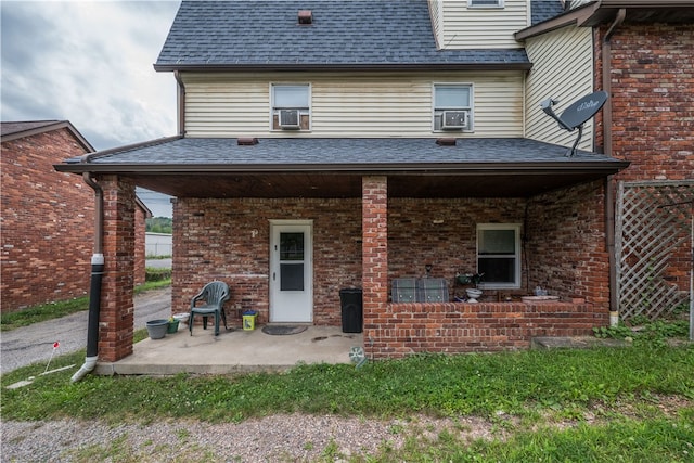 rear view of property with cooling unit and a patio area