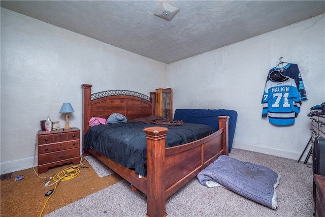 bedroom with a textured ceiling and light carpet