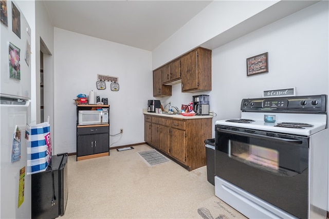 kitchen with dark brown cabinets, white appliances, and sink