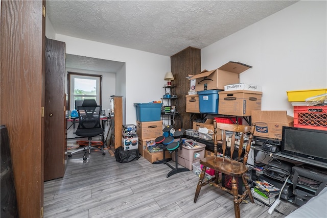 office featuring light wood-type flooring and a textured ceiling