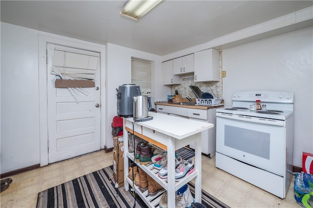 kitchen featuring white cabinetry, sink, light tile patterned floors, decorative backsplash, and white electric stove