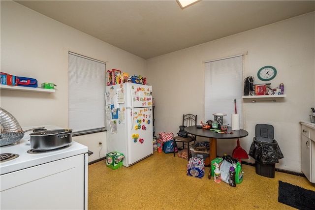 kitchen featuring washer / dryer and white fridge