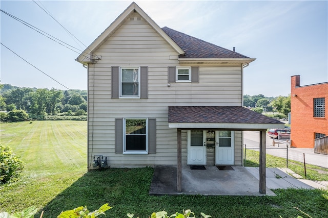 rear view of house with a lawn and a patio area