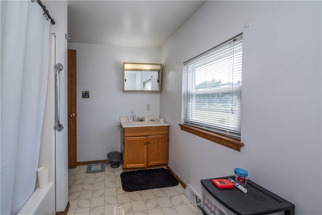 bathroom with washtub / shower combination, vanity, and tile patterned flooring