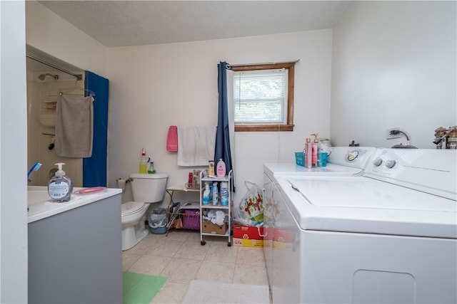 washroom featuring washing machine and dryer and light tile patterned flooring