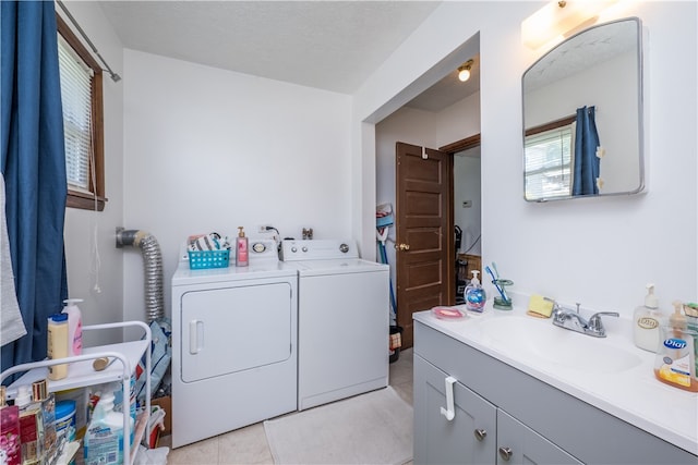 laundry room featuring light tile patterned floors, sink, and washing machine and clothes dryer