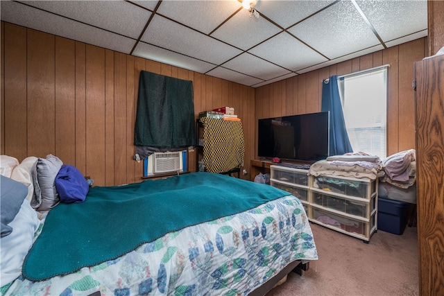 carpeted bedroom with wooden walls, cooling unit, and a drop ceiling