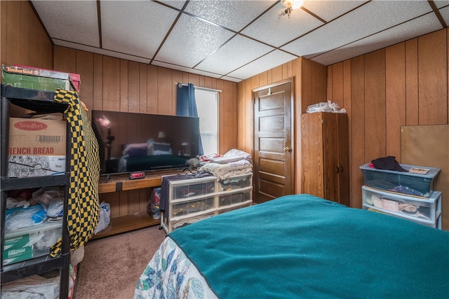 bedroom featuring wooden walls, a paneled ceiling, and carpet floors