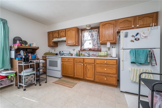 kitchen featuring light tile patterned floors, white appliances, and sink