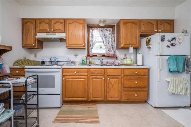 kitchen featuring white appliances, sink, and light tile patterned floors