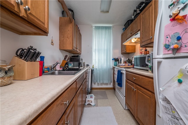 kitchen with sink, white appliances, and light tile patterned floors