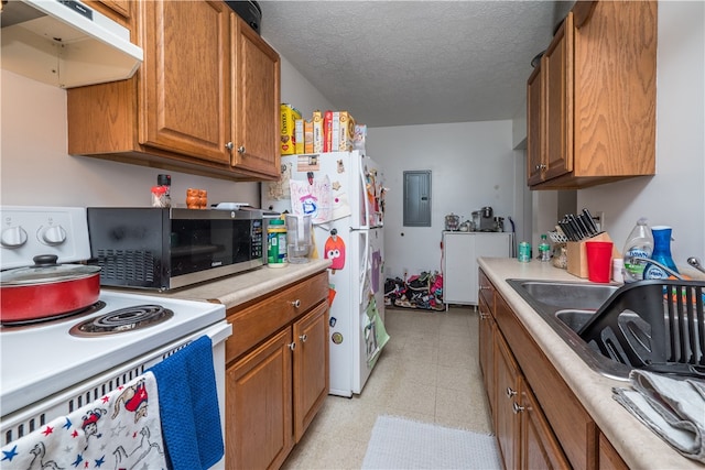 kitchen featuring white appliances, a textured ceiling, electric panel, light tile patterned floors, and sink