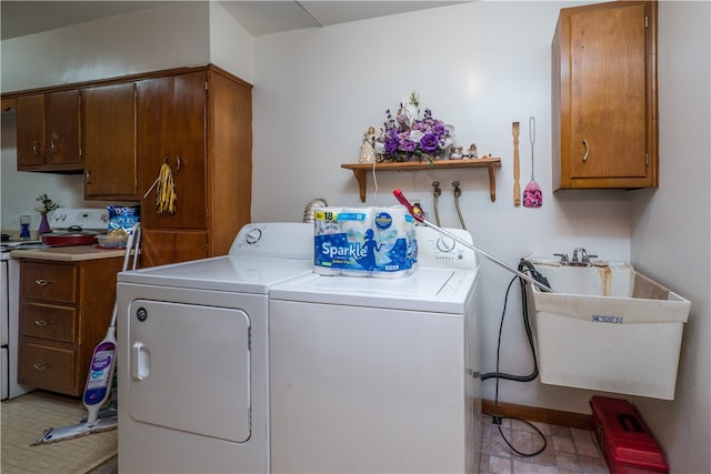 clothes washing area featuring washer and dryer, sink, light tile patterned floors, and cabinets