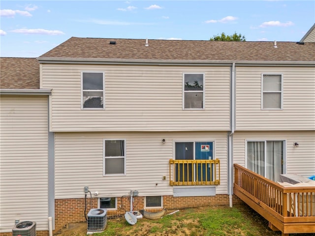 rear view of property with a shingled roof, a deck, and central air condition unit