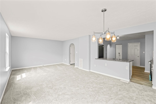 interior space with arched walkways, light carpet, and baseboards