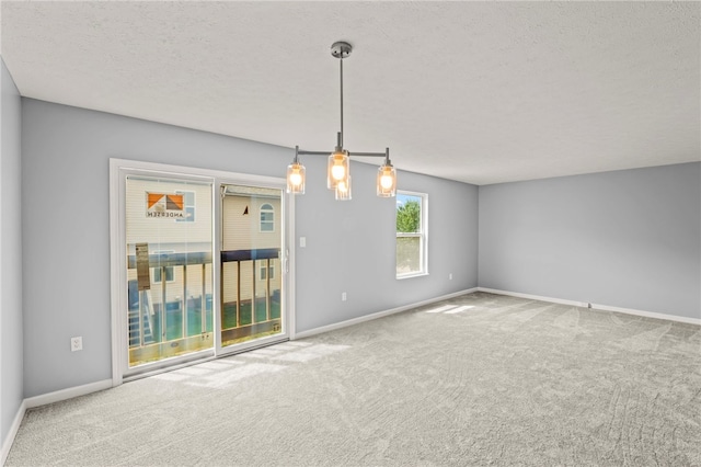 unfurnished room with a textured ceiling, carpet, and baseboards