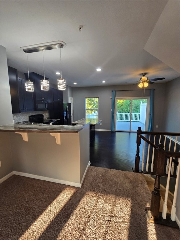 kitchen with blue cabinetry, dark wood-type flooring, stove, a breakfast bar area, and ceiling fan