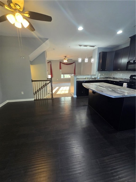 kitchen featuring ceiling fan, wood-type flooring, decorative backsplash, and black appliances