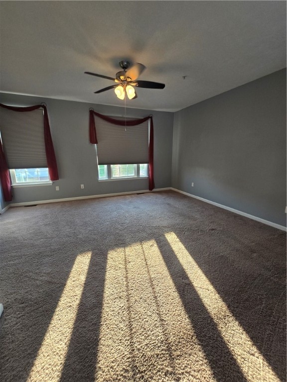 unfurnished room featuring ceiling fan, carpet flooring, and plenty of natural light