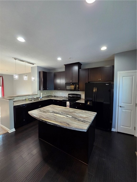 kitchen featuring pendant lighting, a center island, black appliances, dark hardwood / wood-style floors, and dark brown cabinetry