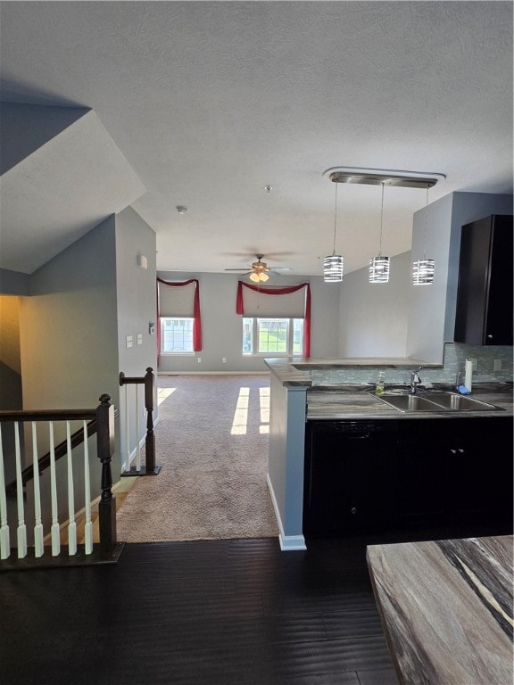 kitchen with ceiling fan, sink, a textured ceiling, and carpet