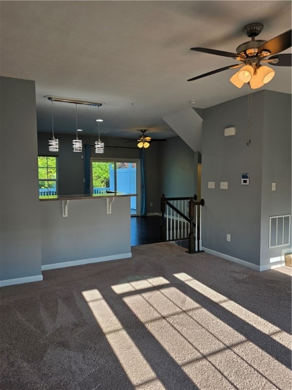 unfurnished living room featuring ceiling fan and carpet floors