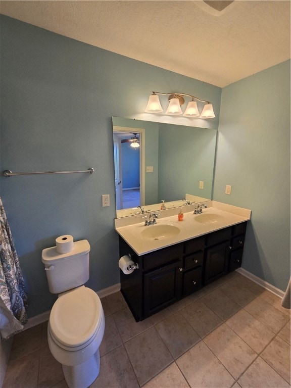 bathroom with ceiling fan, double vanity, tile patterned floors, and toilet