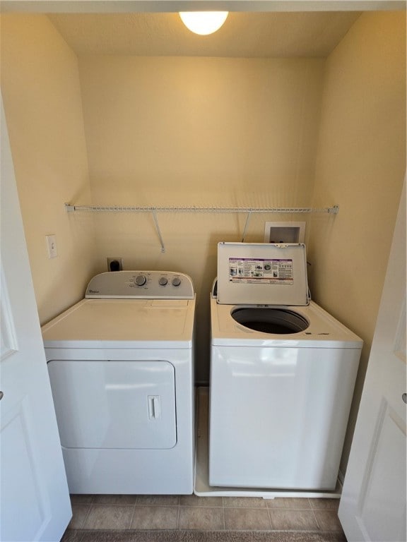 clothes washing area with light tile patterned floors and independent washer and dryer