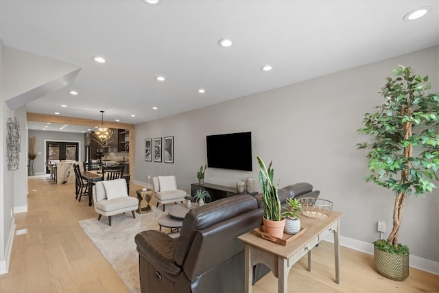 living room with light hardwood / wood-style flooring and a notable chandelier