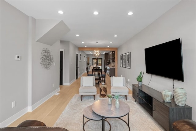 living room with a chandelier and light wood-type flooring