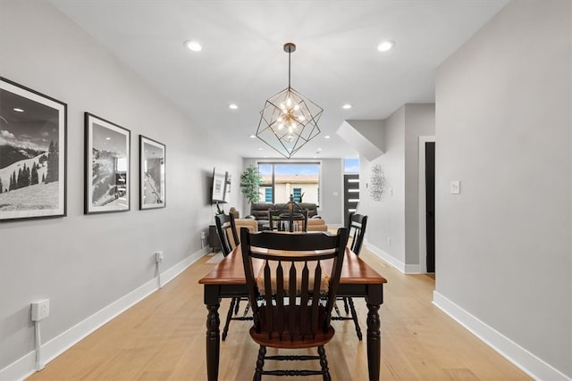 dining space with a chandelier and light wood-type flooring