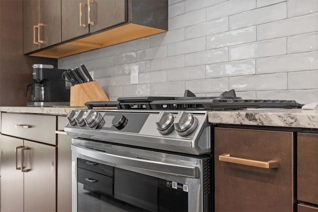 details featuring decorative backsplash, dark brown cabinets, and high end range