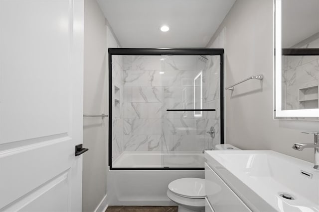 full bathroom with shower / bath combination with glass door, vanity, and toilet