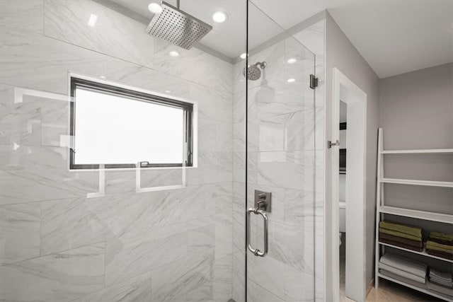 bathroom with toilet and a shower with shower door