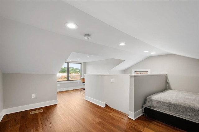 bedroom with hardwood / wood-style flooring and lofted ceiling