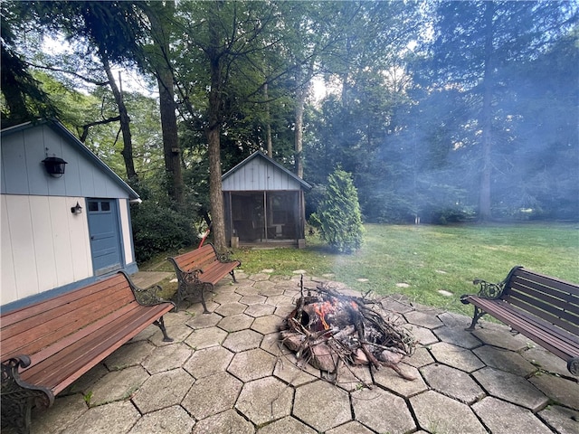 view of patio / terrace featuring a fire pit and a storage unit