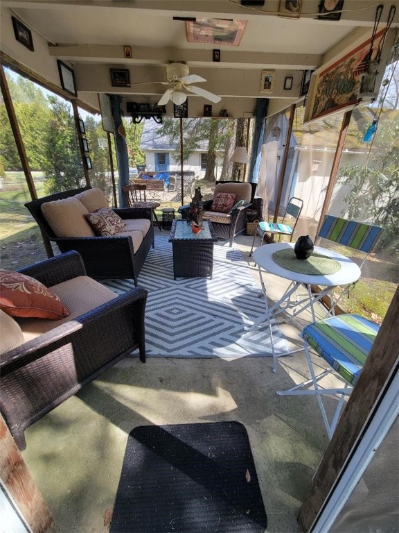 sunroom / solarium featuring ceiling fan