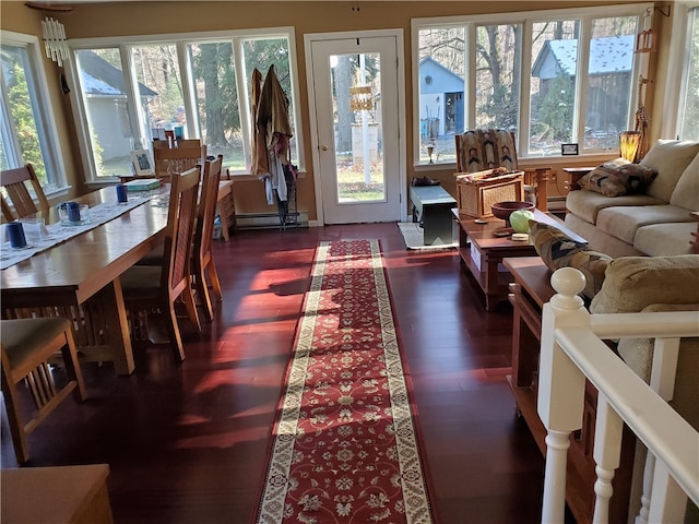 sunroom with a baseboard heating unit and a chandelier