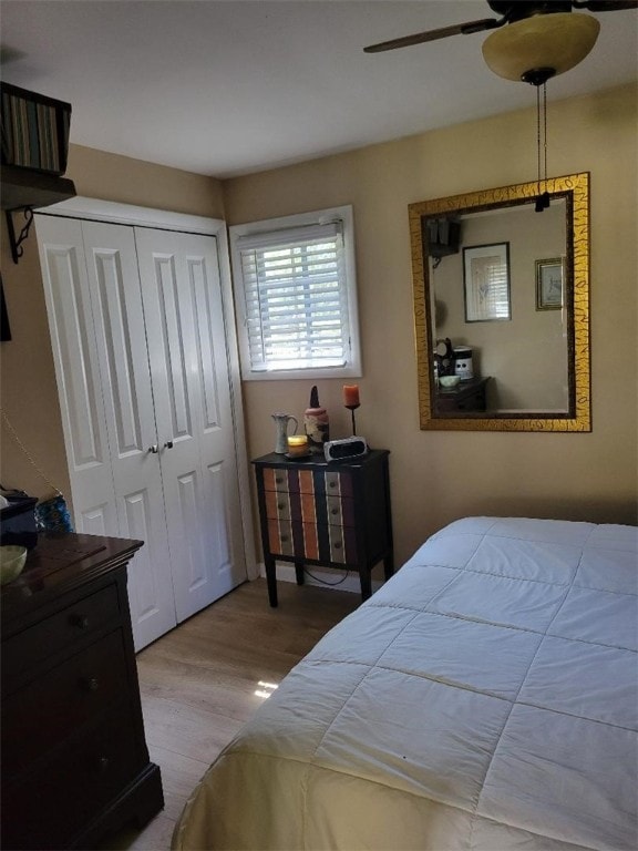 bedroom featuring ceiling fan, light wood-type flooring, and a closet