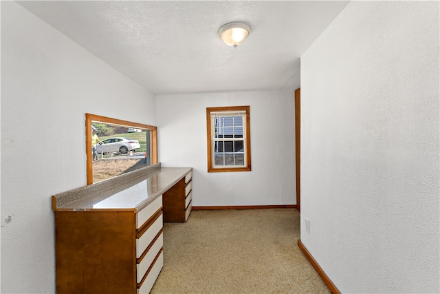 carpeted office space featuring a textured ceiling